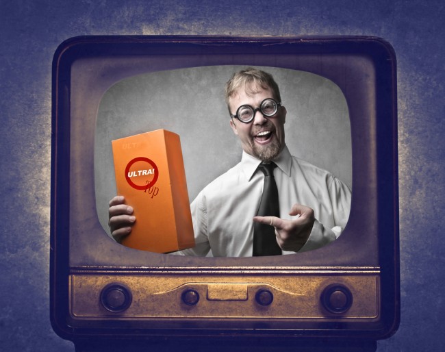 Smiling salesman advertising a product at the television