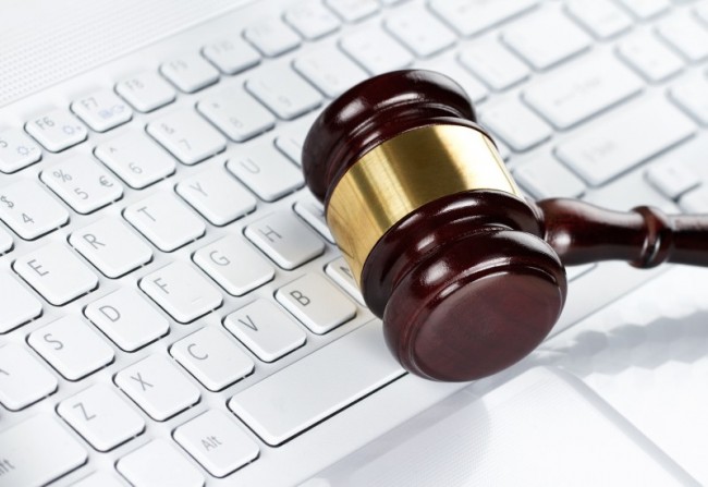 Zdjęcie Close up of wooden gavel at the computer keyboard pochodzi z serwisu Shutterstock 