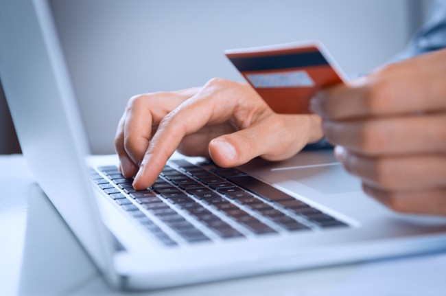 Zdjęcie Close Up Of A Man Shopping Online Using Laptop With Credit Card pochodzi z serwisu ShutterStock class="wp-image-209758" 