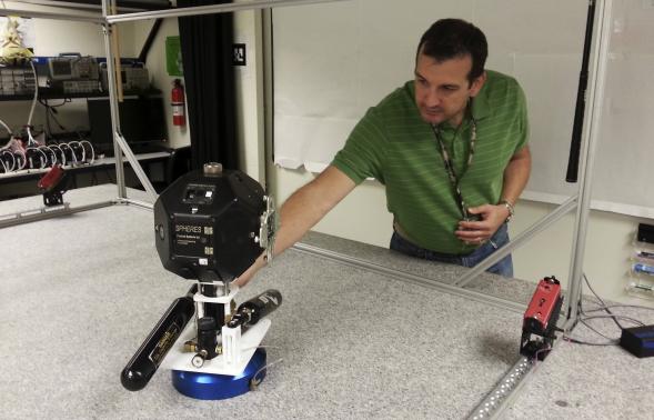 Smart SPHERES project manager Chris Provencher demonstrates one of NASA’s robots at the Ames Research Center in Mountain View, California