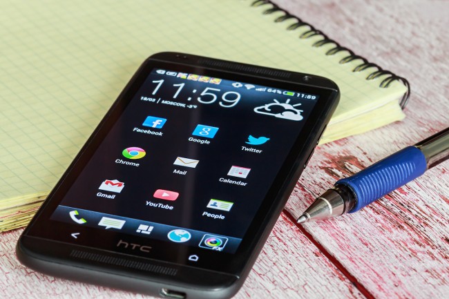 Moscow, Russia March 18, 2014 HTC Mobile Phone with Android applications on the desktop
