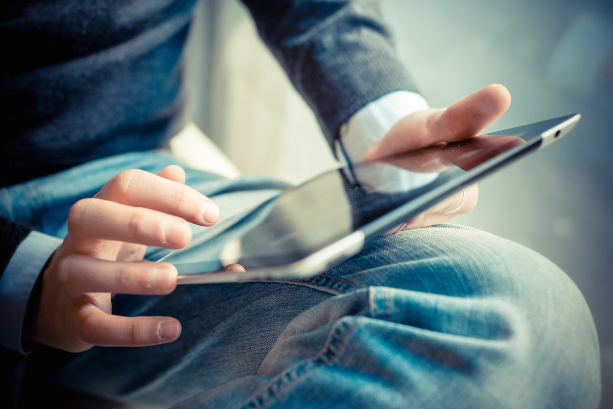 close up hands multitasking man using tablet, laptop and class="wp-image-228213" 
