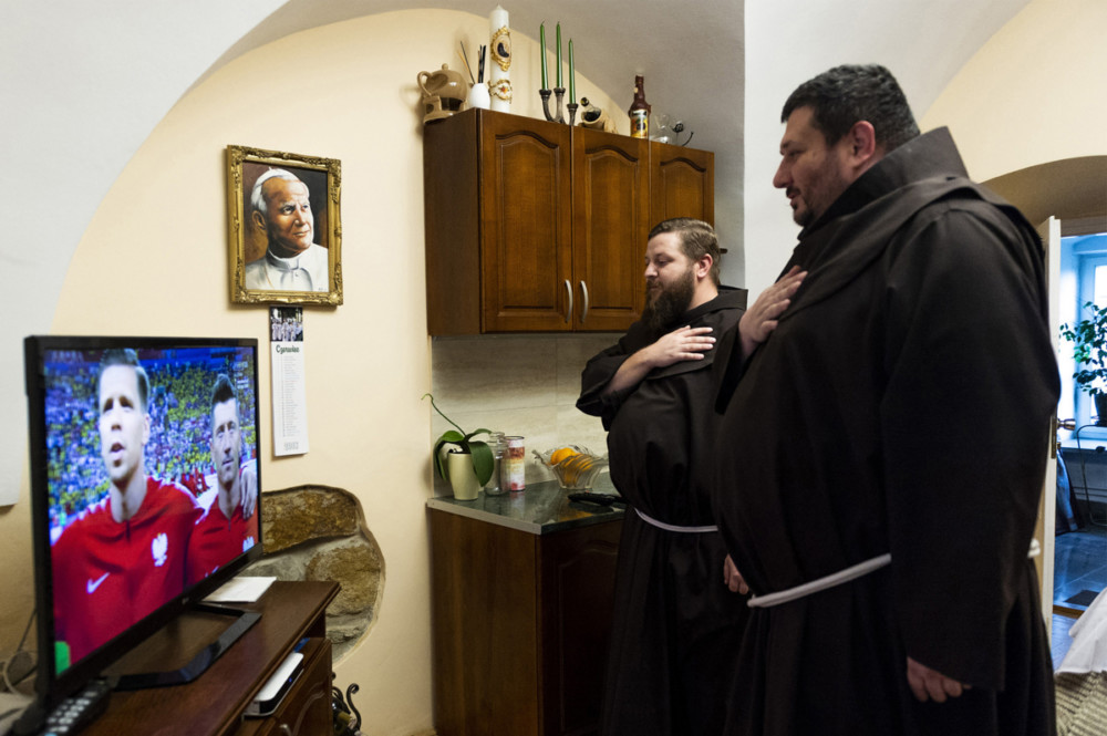 Zdjęcie pojedyncze - II miejsce w kategorii LUDZIE. Fot. Piotr Tracz, dla Agencji Fotograficznej Reporter Małopolska, Zakliczyn. Bracia franciszkanie z zakonu w Zakliczynie podczas hymnu narodowego przed meczem Polska – Kolumbia podczas Mistrzostw Świata w Piłce Nożnej w Rosji. Polska przegrała 0:3. 24 czerwca 2018. class="wp-image-939437" 