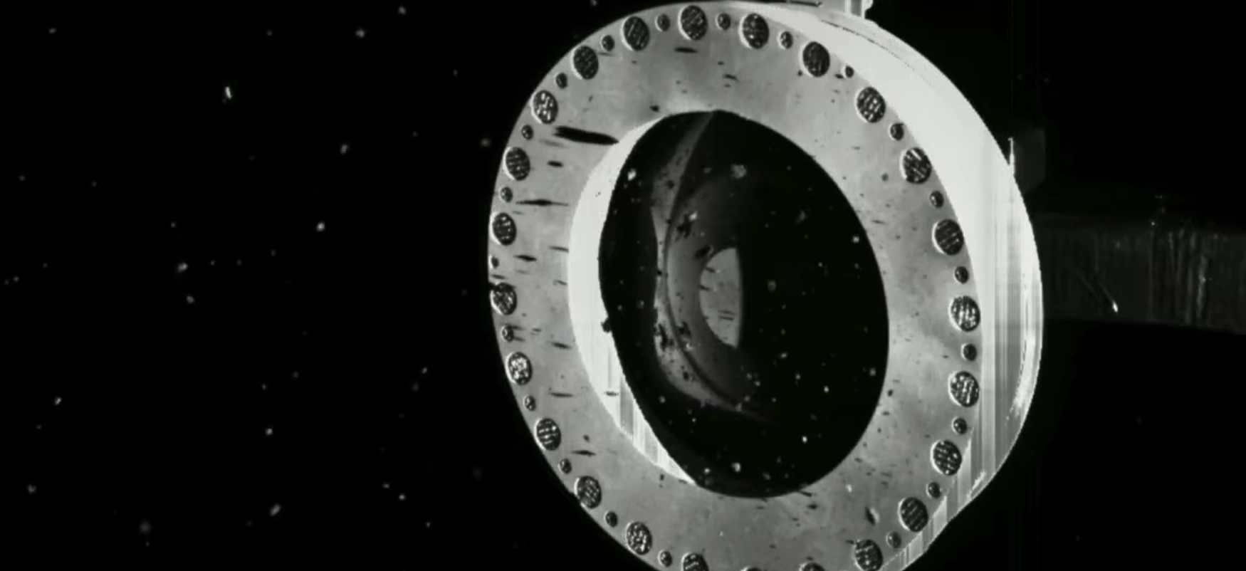 Próbka pobrana z planetoidy Bennu ucieka. Zasobnik sondy OSIRIS-REx wciąż otwarty